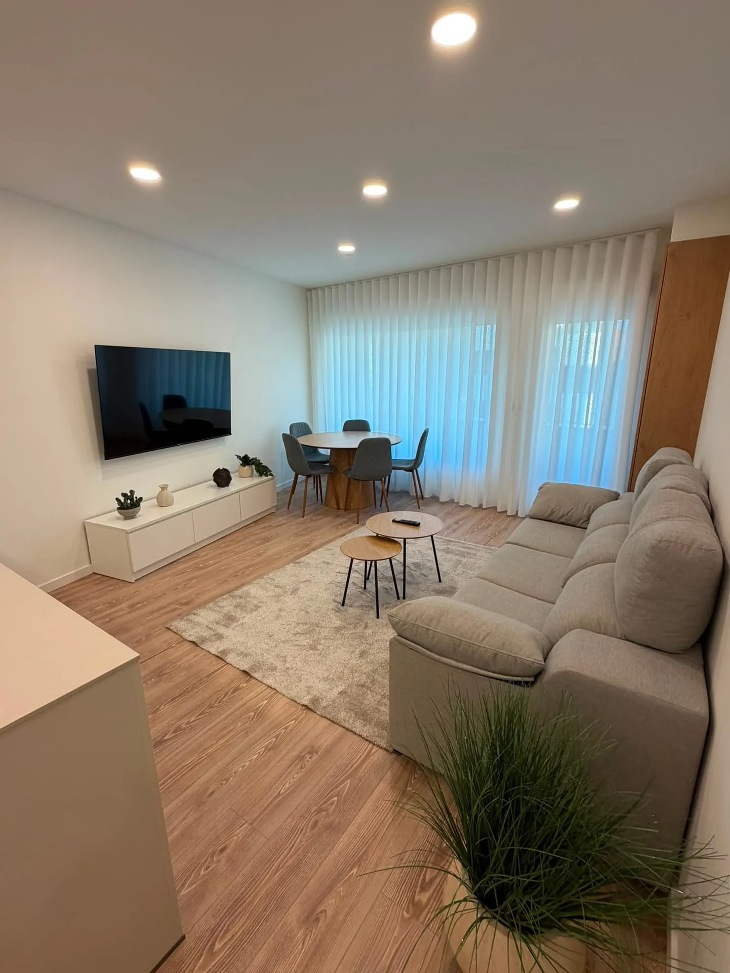 Salón con sofá, mesa de comedor y cortinas onduladas